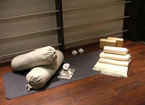 Bolsters folded blankets and straps arranged on a calm floor for relaxation pose preparation